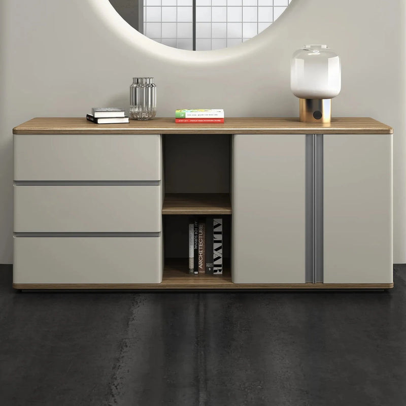 Waverley office credenza beneath a round window cut-out in a gray office, lamp and books on the woodgrain top