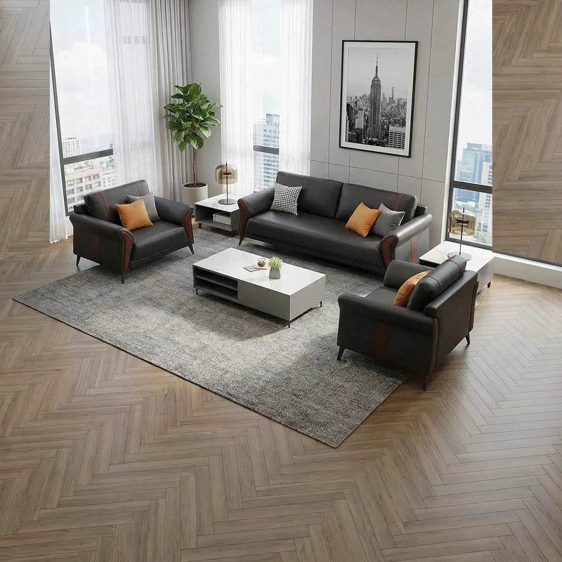 Kiruna black leather lounge set with orange cushions in a corner office with a city skyline print