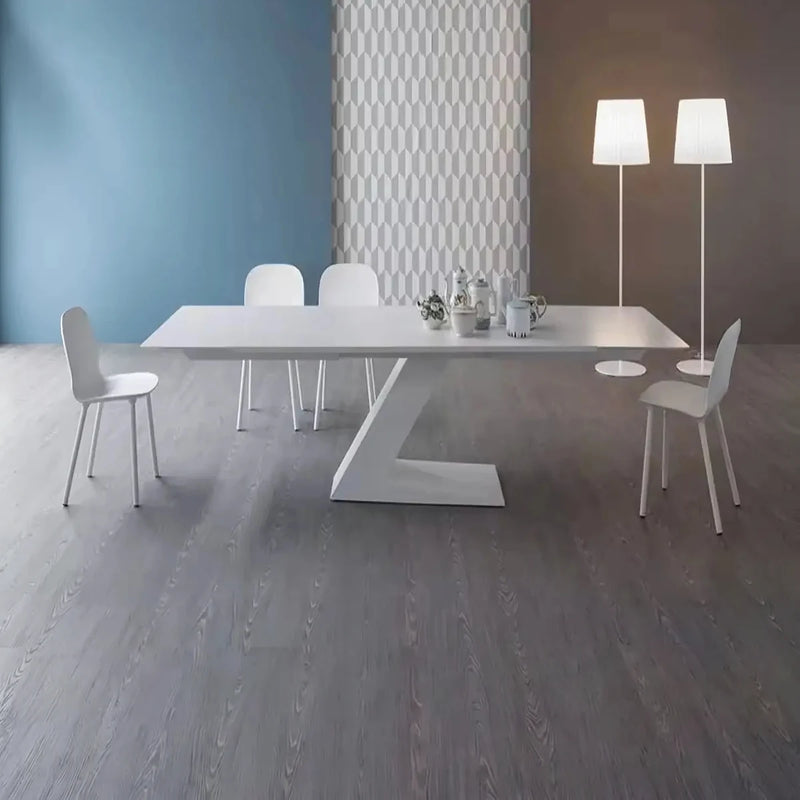 Alara white meeting table with four white chairs in a room with a blue accent wall and floor lamps