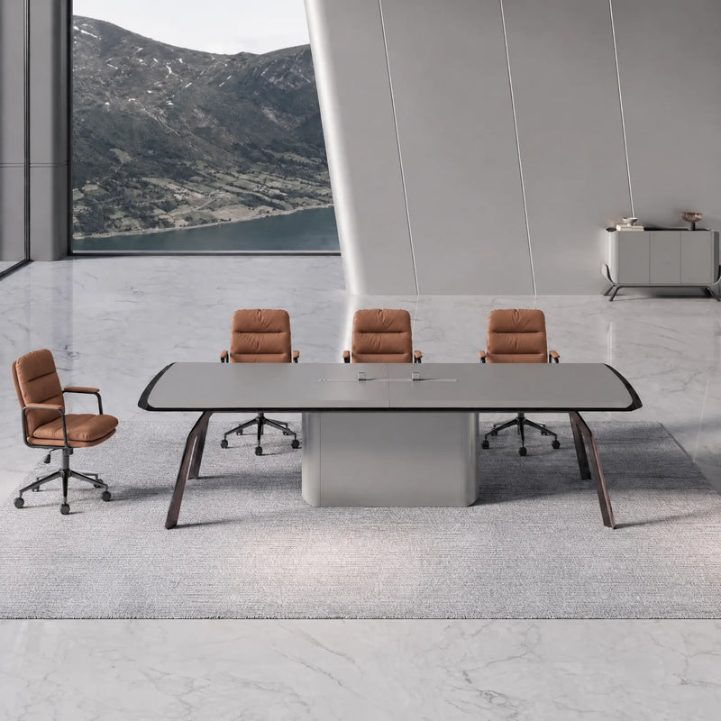 Amalga gray meeting table with tan leather chairs in a stone-floored room overlooking a mountain lake