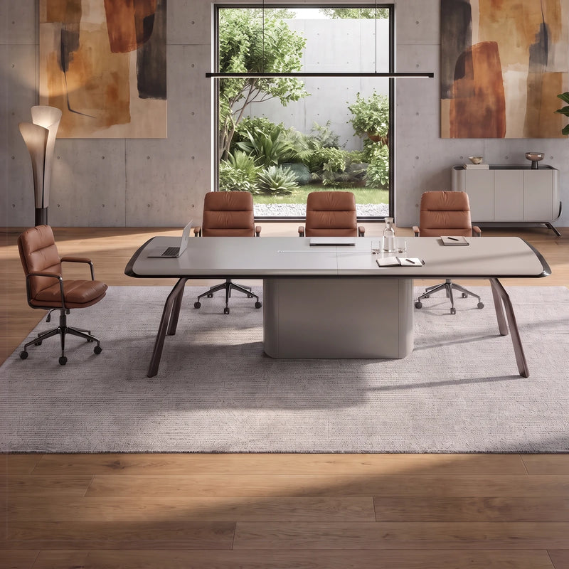 Amalga gray meeting table with tan leather chairs in a stone-floored room overlooking a mountain lake