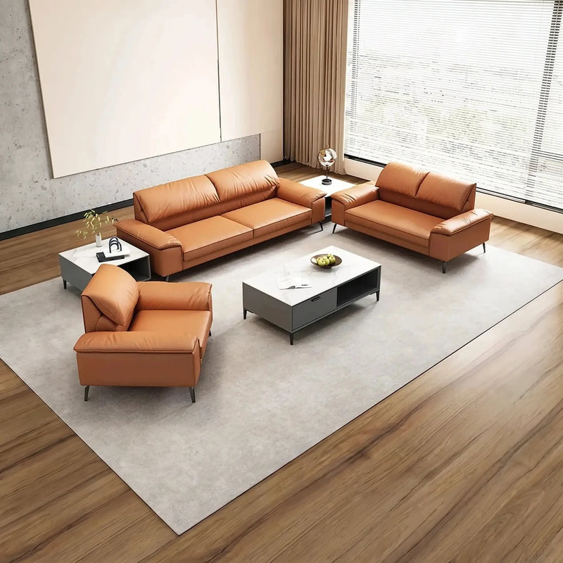 Lomma orange leather lounge set on a pale rug beside a window with blinds, overhead view