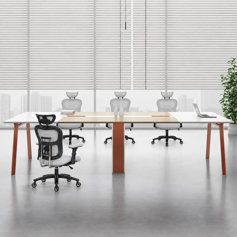 Comity white and beige conference table with orange-seat chairs in an office with window blinds