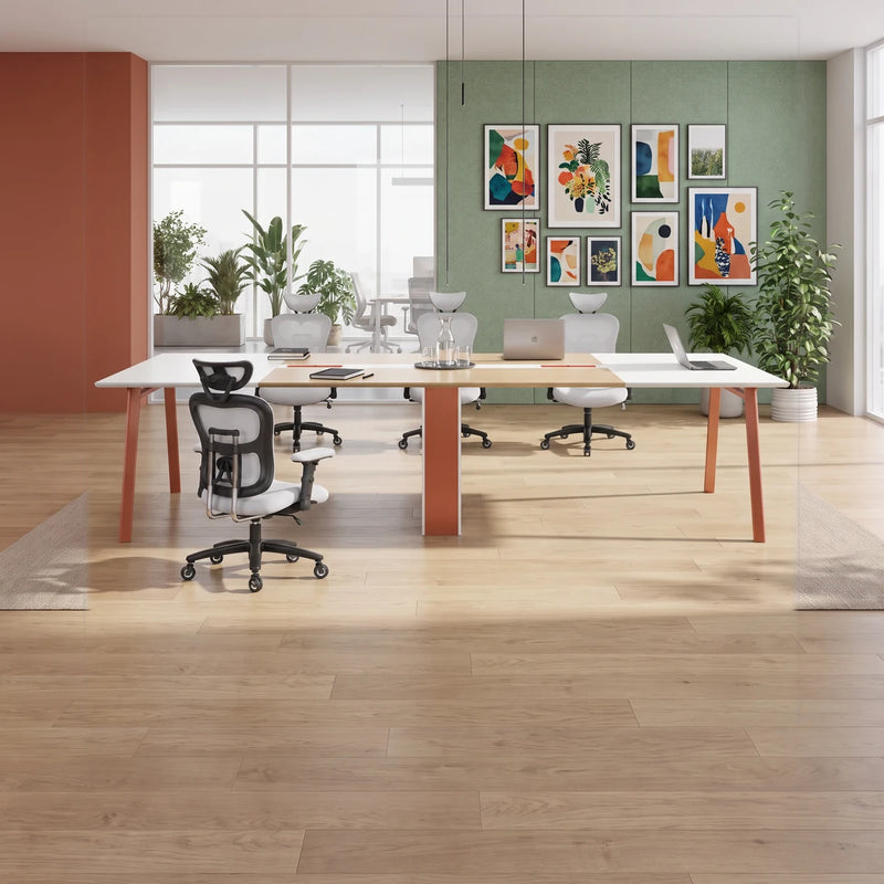 Comity white and beige conference table with orange-seat chairs in an office with window blinds