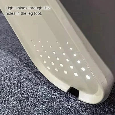 Detail of the Parly blade leg foot with a perforated LED pattern on gray carpet