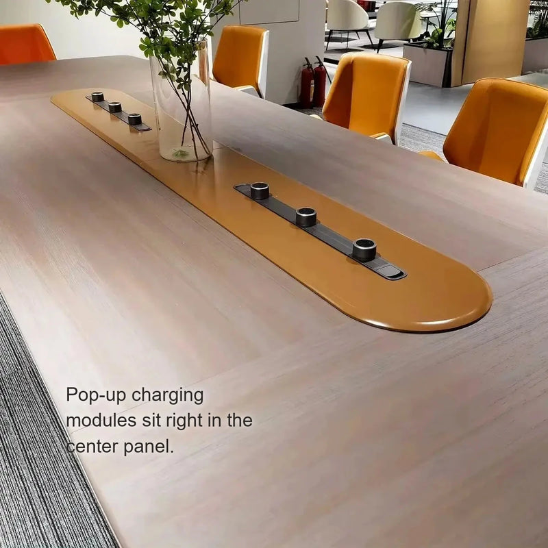 Close-up of the Parly cognac center panel with pop-up charging modules and orange chairs behind