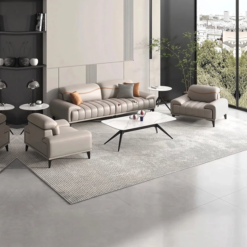 Orust beige lounge set with a white coffee table in a bright office with tall windows and shelving