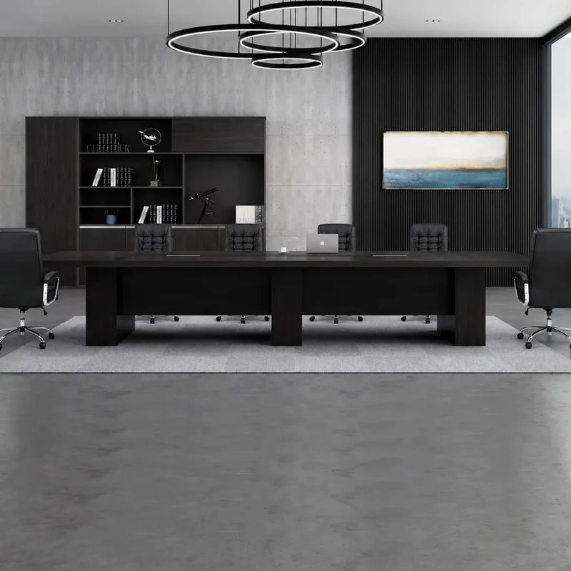 Hendley black boardroom table beneath ring pendant lights in a dark-paneled meeting room