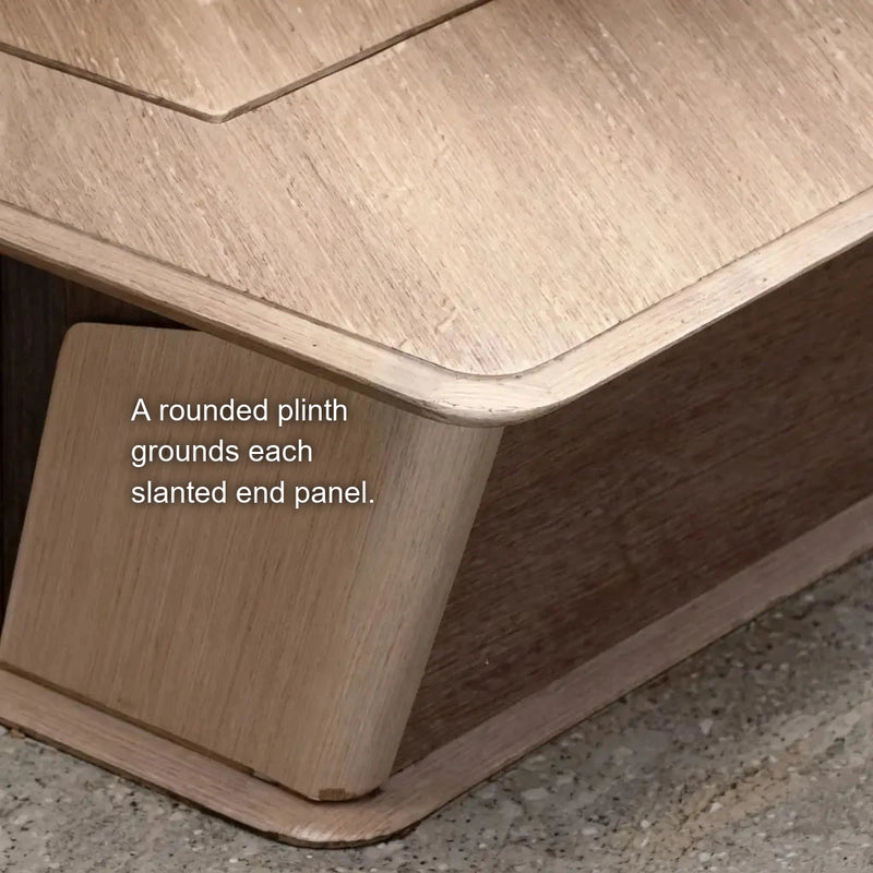 Close-up of the rounded plinth under a slanted end panel of the Cognac desk