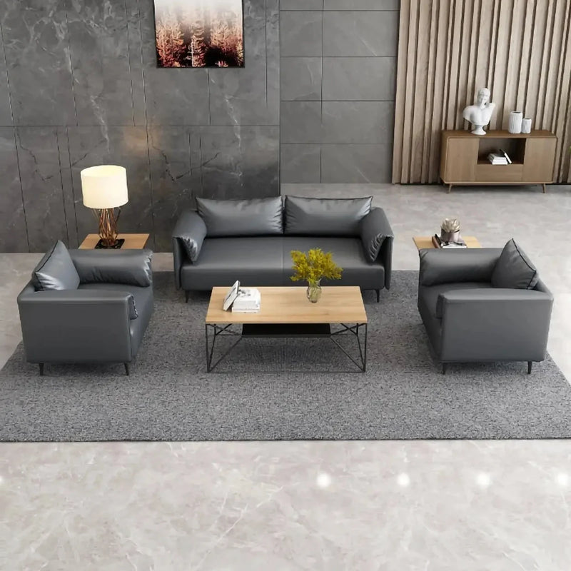 Luleå black leather conversation set on a gray rug in a lobby with a dark stone wall and wood credenza