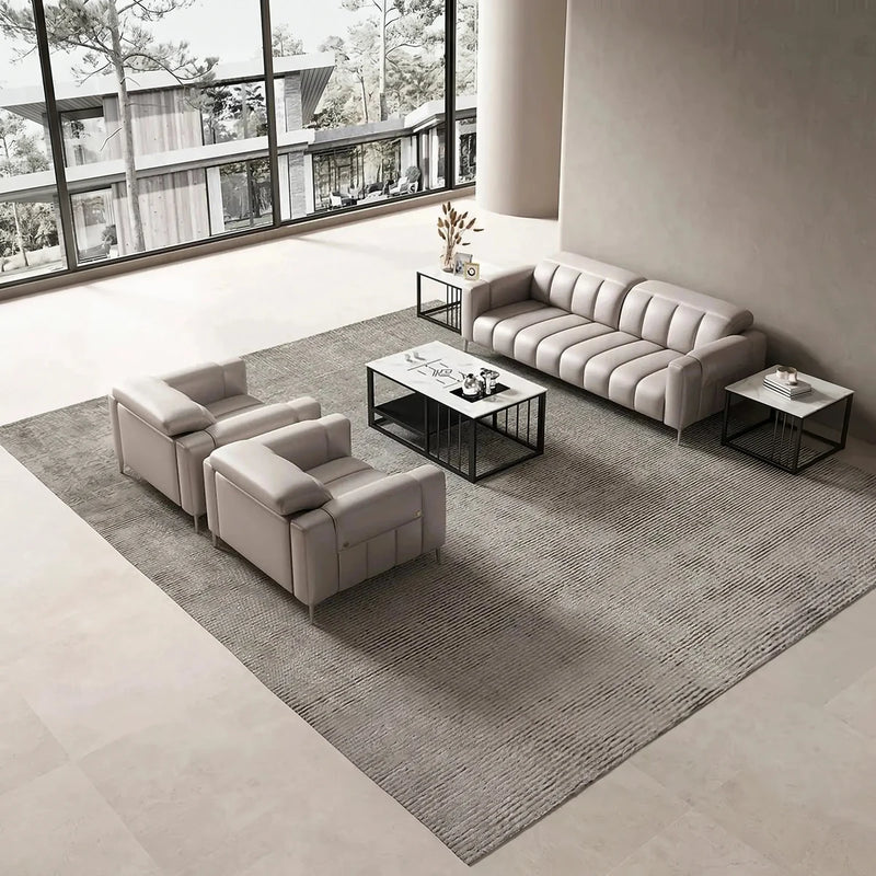 Umeå beige leather conversation set on a gray rug in a lounge with floor-to-ceiling windows, overhead view