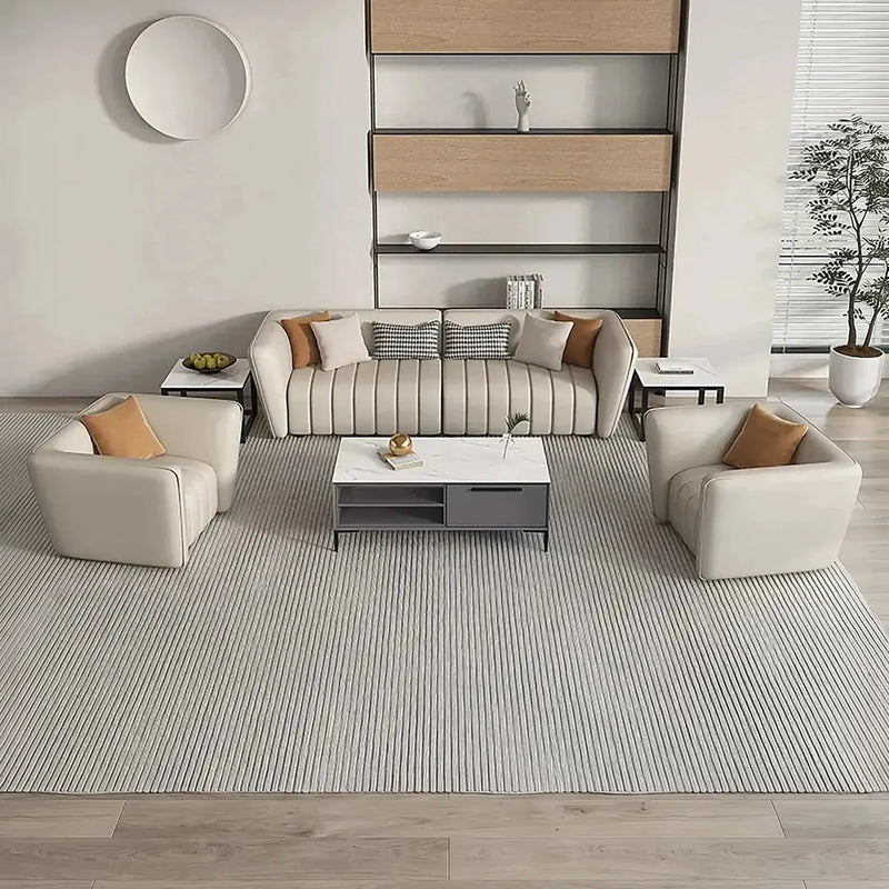 Ven beige lounge set with a white coffee table on a striped rug beneath a round wall mirror