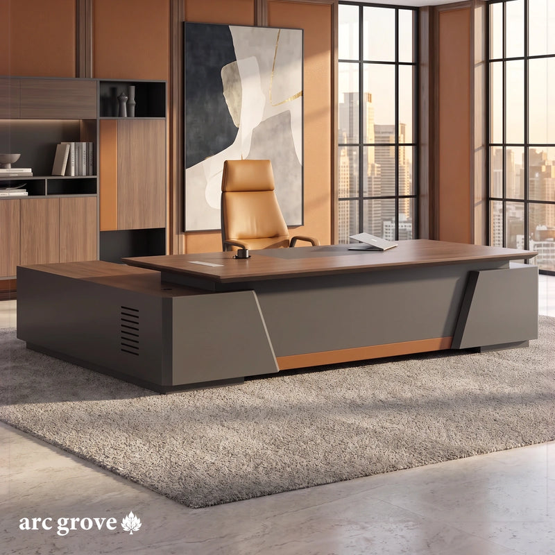 Alford L-shaped executive desk with a walnut top, charcoal gray body and cognac leather strip in an office with leather wall panels and city windows