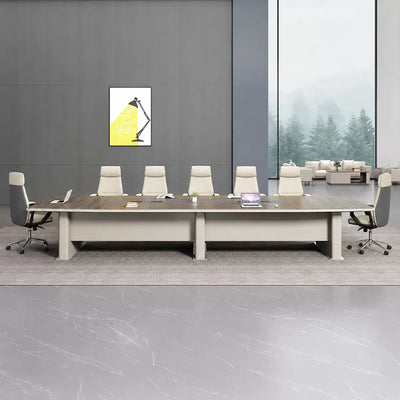Alwyn large conference room table in walnut with ten white chairs in a gray room with a stone floor