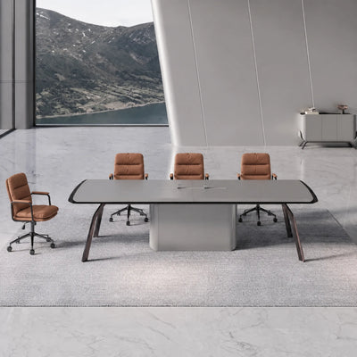 Amalga gray meeting table with tan leather chairs in a stone-floored room overlooking a mountain lake