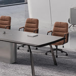 Amalga conference table with cream leather chairs, showing the rounded gray top edge and black legs