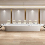 Amica white boardroom table with a row of white chairs in a beige-paneled room with brass trim