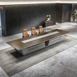 Amiens grand boardroom table in its massive 19′8″ (236-inch) length, seats up to 18, in a black stone-walled room