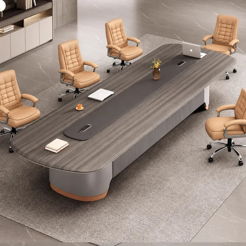 Angled overhead view of the Caliber conference table with a laptop, notebooks and cognac chairs