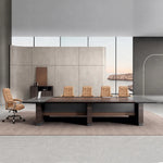 Fuller executive boardroom table in walnut with tan leather chairs against a stone wall and coastal window
