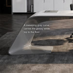 Close-up of the Godel desk's sweeping gray curved leg under the glossy white top