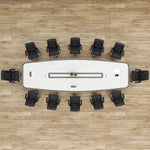 Top-down view of the Harmony white conference table seating 12 in black chairs, center cable channel visible