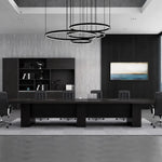 Hendley black boardroom table beneath ring pendant lights in a dark-paneled meeting room
