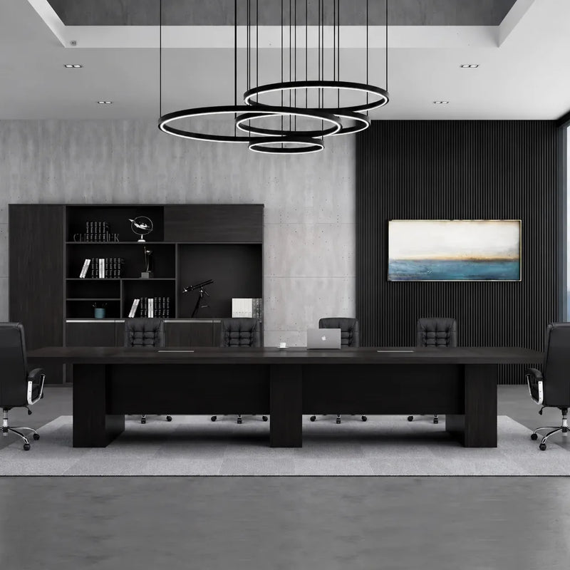 Hendley black boardroom table beneath ring pendant lights in a dark-paneled meeting room