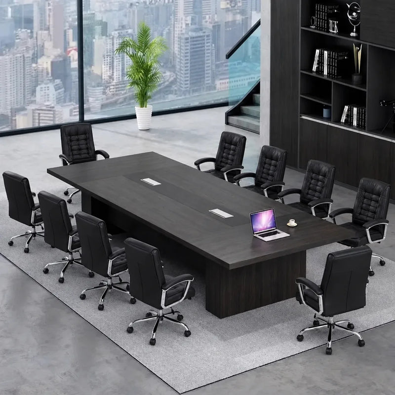 Hendley black conference room table with black leather chairs by a city window, laptop on top