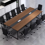 Levan large amber walnut conference table seating 12 in black chairs, angled view with cabinets behind