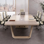 Lyric conference table with a laptop and tan leather chairs, viewed from the head of the table