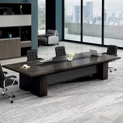 Prime brown conference table with black leather chairs, laptops and a plant in a bright office