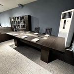 Prime conference table photographed from the side in an office with a bookcase and floor AC unit