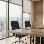 Wright tabletop close up with a laptop and black chairs by a city window
